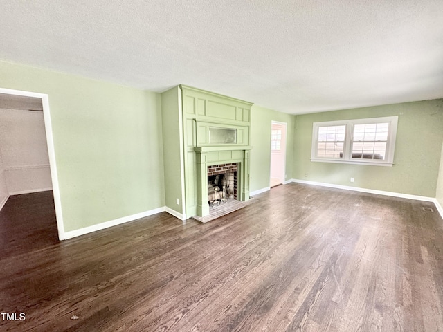 322 S Dixon Ave, Cary, NC 27511 - unfurnished living room with dark wood-type flooring, a textured ceiling, a tile fireplace, and baseboards