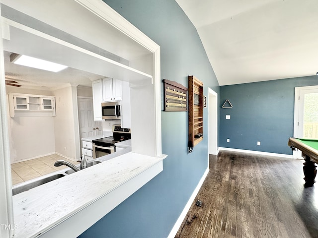 322 S Dixon Ave, Cary, NC 27511 - kitchen with appliances with stainless steel finishes, white cabinetry, pool table, lofted ceiling, and wood finished floors