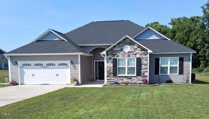 106 Gabor Ln, Goldsboro, NC 27530 - view of front of home with an attached garage, a front lawn, driveway, and stone siding