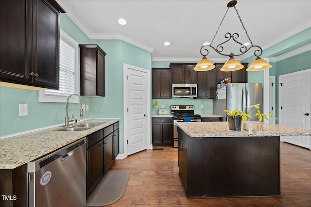 224 Swann Trl, Clayton, NC 27527 - kitchen featuring appliances with stainless steel finishes, a sink, dark brown cabinets, a kitchen island, and ornamental molding