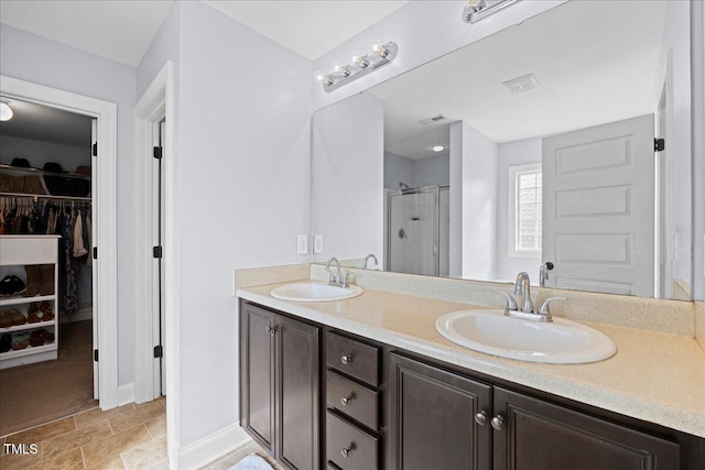 224 Swann Trl, Clayton, NC 27527 - full bath with a stall shower, double vanity, a walk in closet, baseboards, and stone finish floors