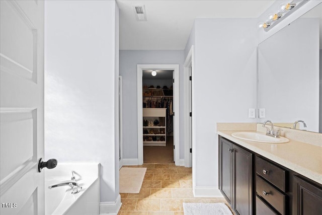 224 Swann Trl, Clayton, NC 27527 - full bath featuring vanity, a garden tub, baseboards, and a spacious closet