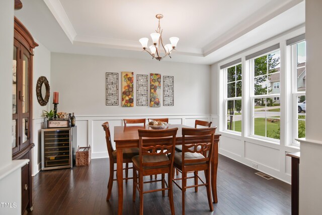 8909 Tara Hill Ln, Wake Forest, NC 27587 - dining space featuring a raised ceiling, beverage cooler, a chandelier, dark wood-style floors, and a decorative wall