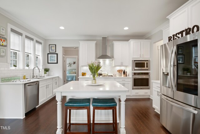 8909 Tara Hill Ln, Wake Forest, NC 27587 - kitchen with appliances with stainless steel finishes, wall chimney range hood, a sink, decorative backsplash, and ornamental molding