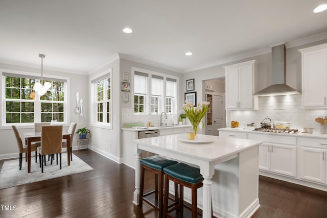 8909 Tara Hill Ln, Wake Forest, NC 27587 - kitchen with wall chimney range hood, crown molding, light countertops, white cabinets, and a kitchen breakfast bar
