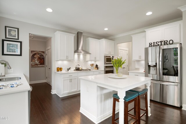 8909 Tara Hill Ln, Wake Forest, NC 27587 - kitchen with appliances with stainless steel finishes, wall chimney exhaust hood, a sink, white cabinets, and a breakfast bar