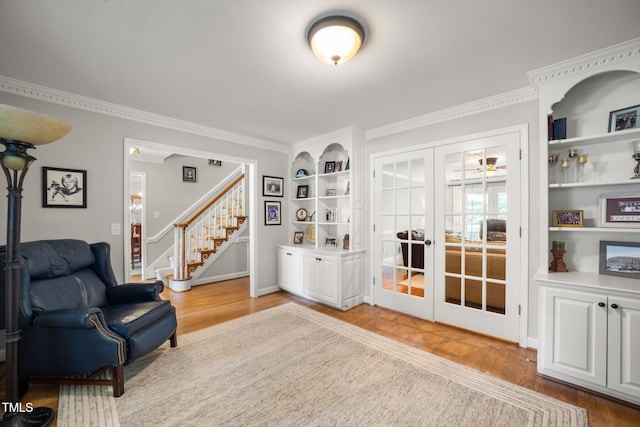 102 Pin Oak Ct, Elon, NC 27244 - sitting room featuring wood finished floors, french doors, built in features, stairs, and crown molding