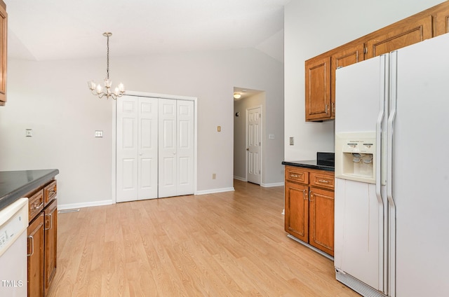 2108 Carthage Cir, Raleigh, NC 27604 - kitchen featuring white appliances, brown cabinets, a chandelier, dark countertops, and lofted ceiling