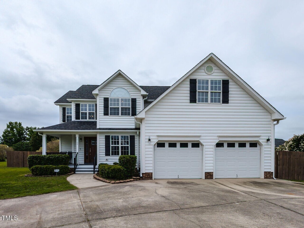 1100 Open Field Dr, Garner, NC 27529 - traditional-style home featuring driveway, a shingled roof, a garage, and a porch