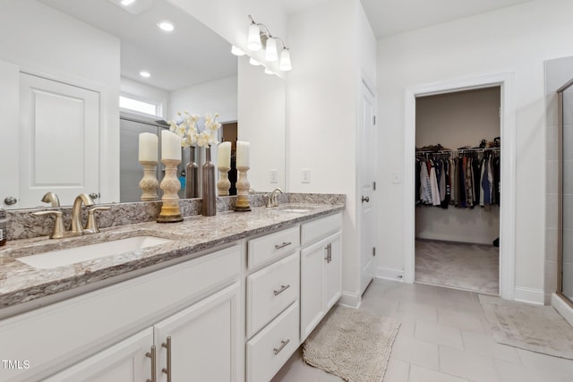 404 Porterfield Dr, Youngsville, NC 27596 - bathroom featuring double vanity, a shower stall, a walk in closet, and recessed lighting