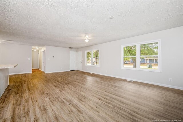 6313 Belle Terre Ct, Fayetteville, NC 28304 - unfurnished living room with wood finished floors, a textured ceiling, baseboards, and a ceiling fan