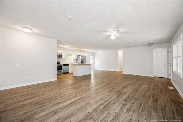 6313 Belle Terre Ct, Fayetteville, NC 28304 - unfurnished living room featuring a textured ceiling, a ceiling fan, wood finished floors, and baseboards