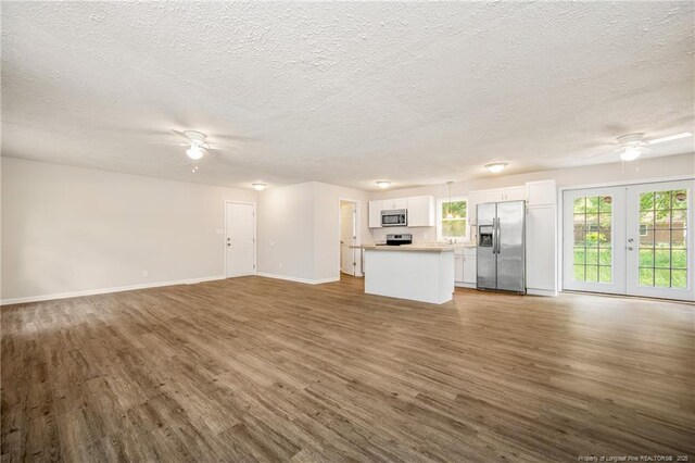 6313 Belle Terre Ct, Fayetteville, NC 28304 - unfurnished living room featuring a ceiling fan, baseboards, wood finished floors, a textured ceiling, and french doors