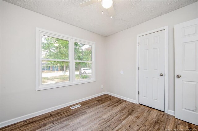 6313 Belle Terre Ct, Fayetteville, NC 28304 - empty room featuring wood finished floors, a textured ceiling, a ceiling fan, and baseboards