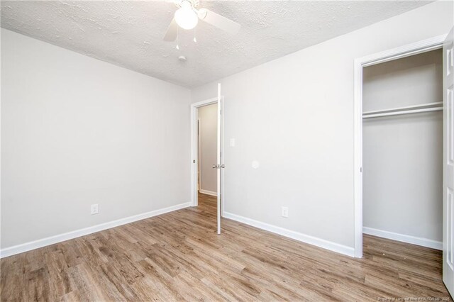 6313 Belle Terre Ct, Fayetteville, NC 28304 - unfurnished bedroom with wood finished floors, a closet, a textured ceiling, baseboards, and a ceiling fan