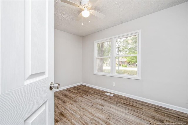 6313 Belle Terre Ct, Fayetteville, NC 28304 - empty room featuring wood finished floors, baseboards, a textured ceiling, and ceiling fan
