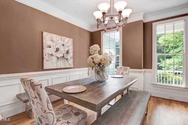 1128 Neuse Ridge Dr, Clayton, NC 27527 - dining area featuring a chandelier, plenty of natural light, light wood-type flooring, crown molding, and wainscoting