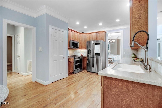 1128 Neuse Ridge Dr, Clayton, NC 27527 - kitchen featuring appliances with stainless steel finishes, a sink, ornamental molding, a chandelier, and decorative backsplash