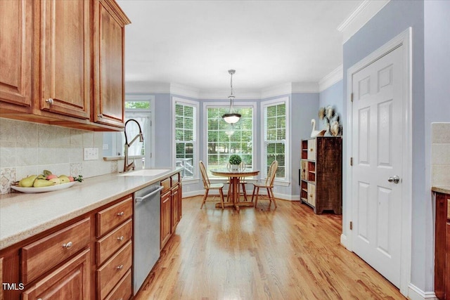 1128 Neuse Ridge Dr, Clayton, NC 27527 - kitchen featuring stainless steel dishwasher, a sink, light wood-style floors, brown cabinets, and crown molding