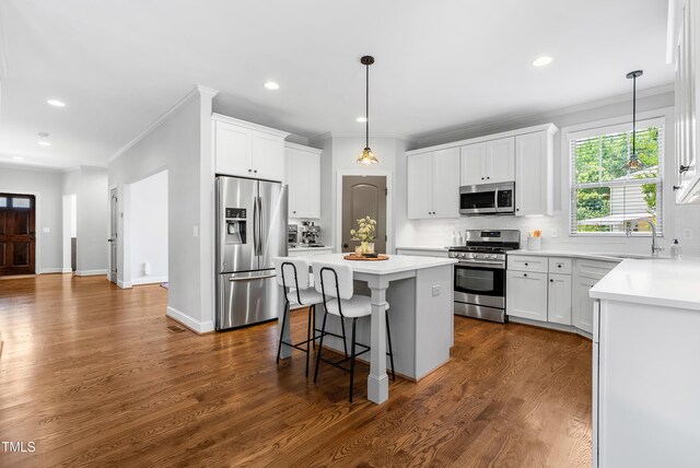 118 Fox Run Ct, Durham, NC 27705 - kitchen with stainless steel appliances, a sink, a center island, ornamental molding, and tasteful backsplash