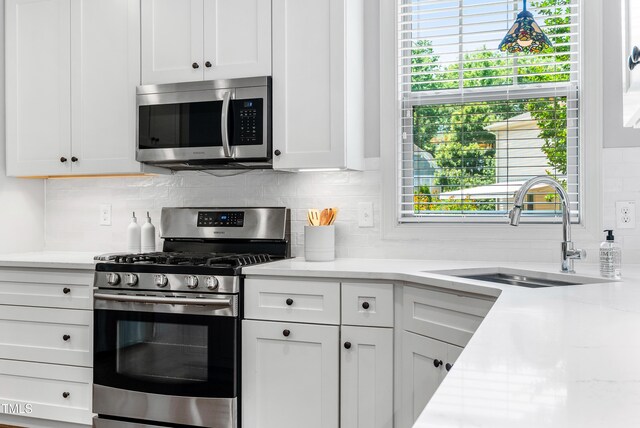 118 Fox Run Ct, Durham, NC 27705 - kitchen with appliances with stainless steel finishes, a sink, backsplash, and white cabinets