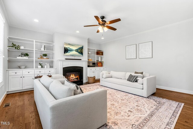 118 Fox Run Ct, Durham, NC 27705 - living area with a ceiling fan, ornamental molding, a glass covered fireplace, wood finished floors, and healthy amount of natural light