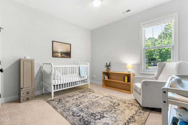 118 Fox Run Ct, Durham, NC 27705 - carpeted bedroom featuring a nursery area and baseboards