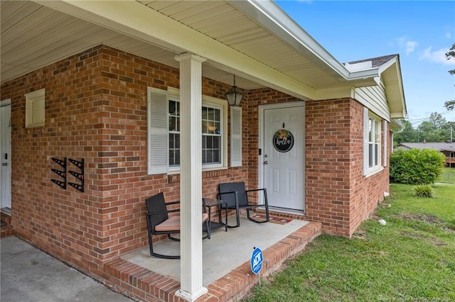 701 Dandridge Dr, Fayetteville, NC 28304 - view of exterior entry featuring brick siding, a porch, and a lawn