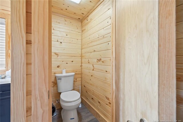 701 Dandridge Dr, Fayetteville, NC 28304 - bathroom featuring toilet, wood walls, and wood finished floors