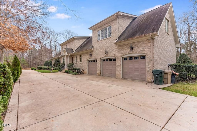 166 Bonica Creek Dr, Garner, NC 27529 - view of side of home featuring driveway, brick siding, a garage, and roof with shingles