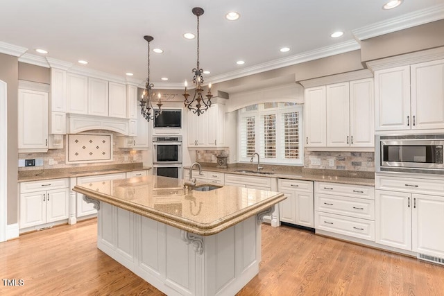 166 Bonica Creek Dr, Garner, NC 27529 - kitchen featuring a sink, appliances with stainless steel finishes, a chandelier, white cabinetry, and ornamental molding