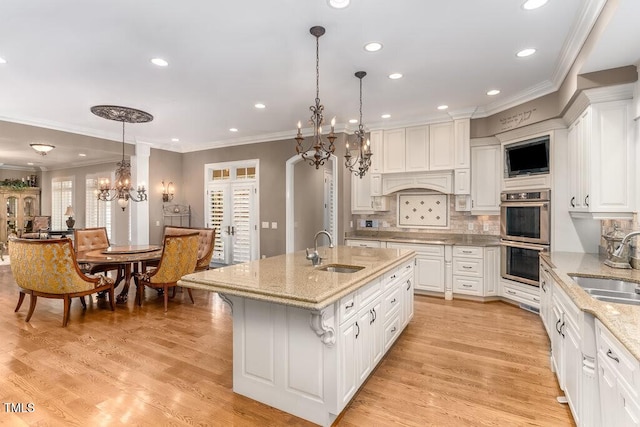 166 Bonica Creek Dr, Garner, NC 27529 - kitchen featuring a chandelier, stainless steel double oven, a sink, ornamental molding, and white cabinetry