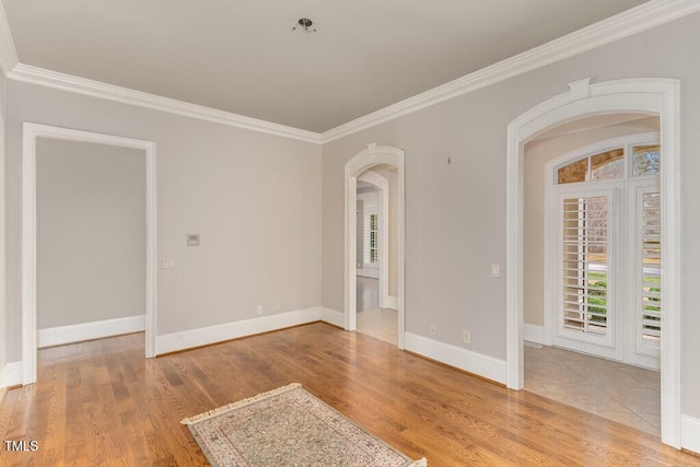 166 Bonica Creek Dr, Garner, NC 27529 - empty room featuring arched walkways, crown molding, healthy amount of natural light, wood finished floors, and baseboards