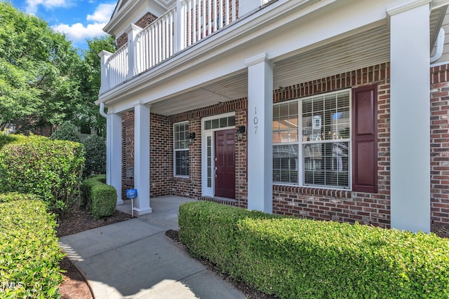 10511 Sablewood Dr Unit 107, Raleigh, NC 27617 - doorway to property featuring brick siding, a balcony, and a porch