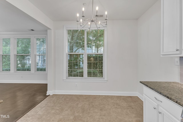 10511 Sablewood Dr Unit 107, Raleigh, NC 27617 - unfurnished dining area featuring a chandelier and baseboards