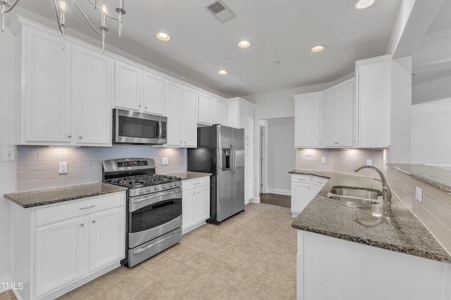 10511 Sablewood Dr Unit 107, Raleigh, NC 27617 - kitchen with appliances with stainless steel finishes, backsplash, white cabinetry, recessed lighting, and dark stone countertops