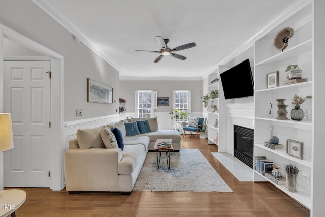 1905 Indianwood Ct, Raleigh, NC 27604 - living room with a ceiling fan, ornamental molding, a fireplace with flush hearth, built in shelves, and wainscoting