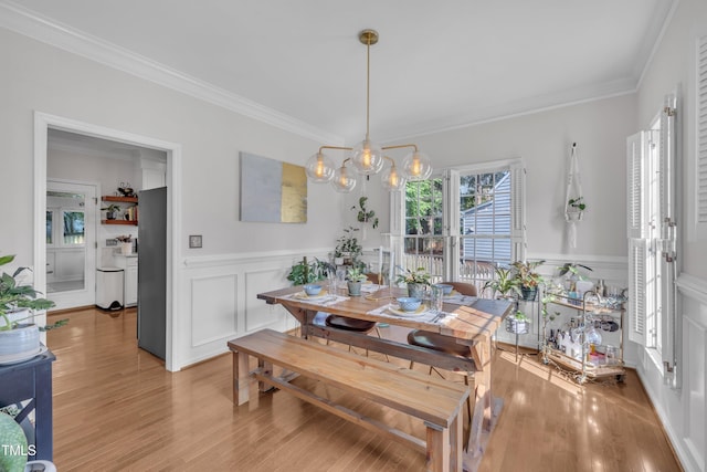 1905 Indianwood Ct, Raleigh, NC 27604 - dining area featuring a decorative wall, crown molding, wainscoting, and light wood-style flooring