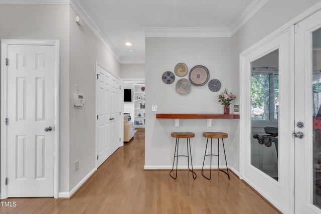 1905 Indianwood Ct, Raleigh, NC 27604 - kitchen featuring ornamental molding, wood finished floors, a kitchen bar, baseboards, and recessed lighting