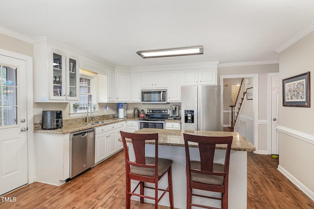 110 Windyfield Dr, Goldsboro, NC 27530 - kitchen featuring appliances with stainless steel finishes, crown molding, wood finished floors, white cabinets, and glass insert cabinets