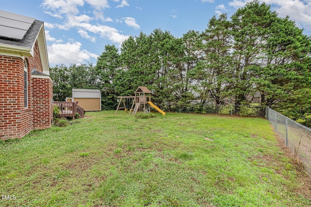 110 Windyfield Dr, Goldsboro, NC 27530 - fenced backyard featuring a playground, a wooden deck, view of scattered trees, and a shed