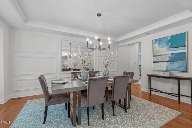 101 Quarryrock Rd, Holly Springs, NC 27540 - dining space with a chandelier, light wood-type flooring, ornamental molding, baseboards, and a decorative wall