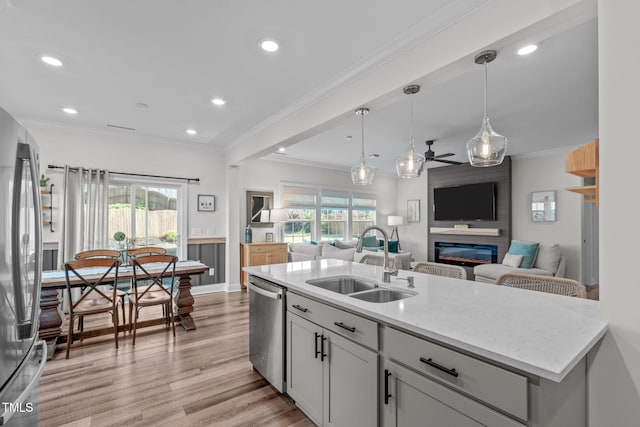 512 Teal Lake Dr, Holly Springs, NC 27540 - kitchen with a sink, appliances with stainless steel finishes, open floor plan, light wood-type flooring, and a large fireplace