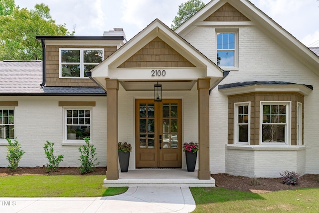 2100 Summit St, Durham, NC 27707 - view of exterior entry with brick siding, roof with shingles, and french doors