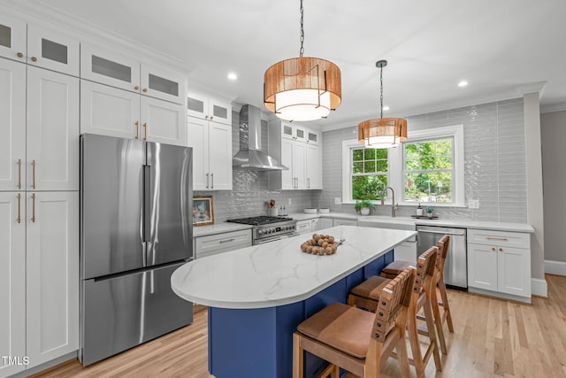 2100 Summit St, Durham, NC 27707 - kitchen with stainless steel appliances, wall chimney exhaust hood, backsplash, light wood-style floors, and a kitchen bar