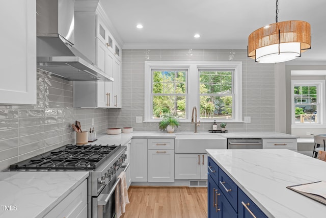 2100 Summit St, Durham, NC 27707 - kitchen featuring wall chimney exhaust hood, stainless steel appliances, a sink, blue cabinets, and white cabinetry