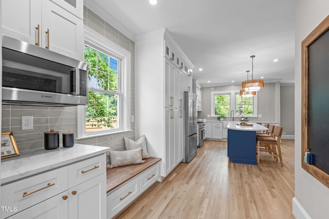 2100 Summit St, Durham, NC 27707 - kitchen featuring backsplash, stainless steel appliances, recessed lighting, white cabinetry, and a breakfast bar