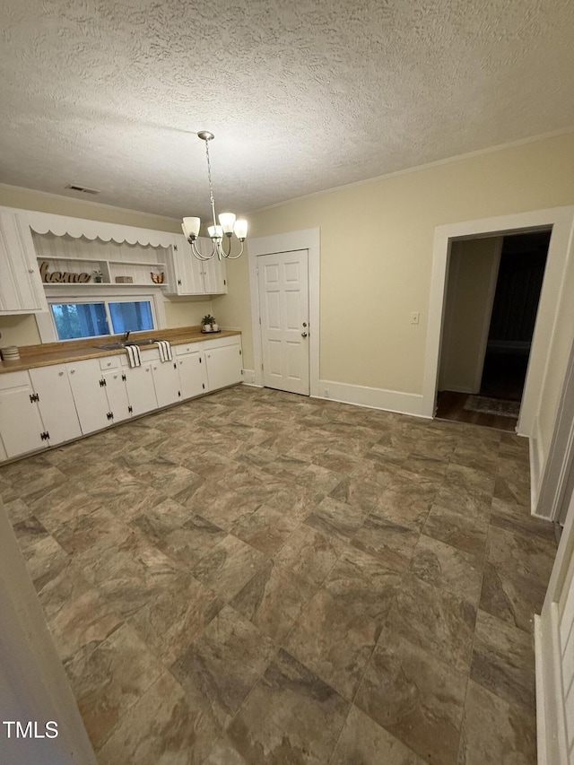 340 Jones Rd, Newton Grove, NC 28366 - unfurnished dining area with a chandelier, a textured ceiling, and baseboards
