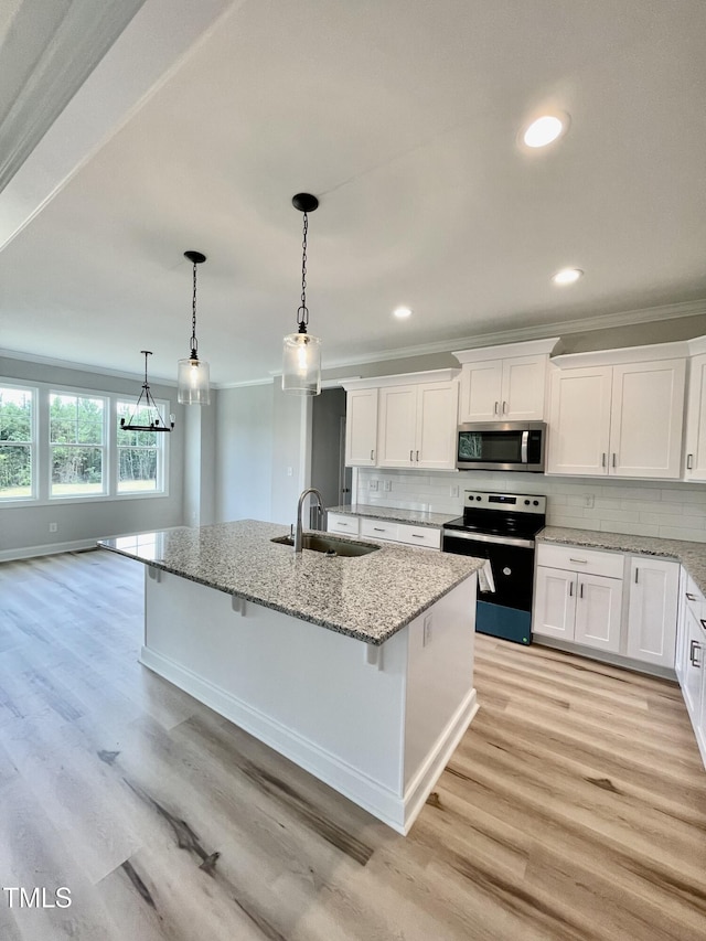 6786 Fire Tower Rd, Bailey, NC 27807 - kitchen with electric stove, a sink, crown molding, stainless steel microwave, and a center island with sink