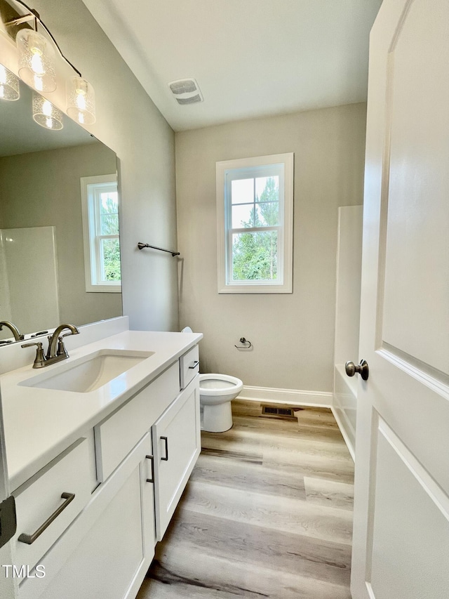 6786 Fire Tower Rd, Bailey, NC 27807 - full bath with vanity, toilet, wood finished floors, and baseboards